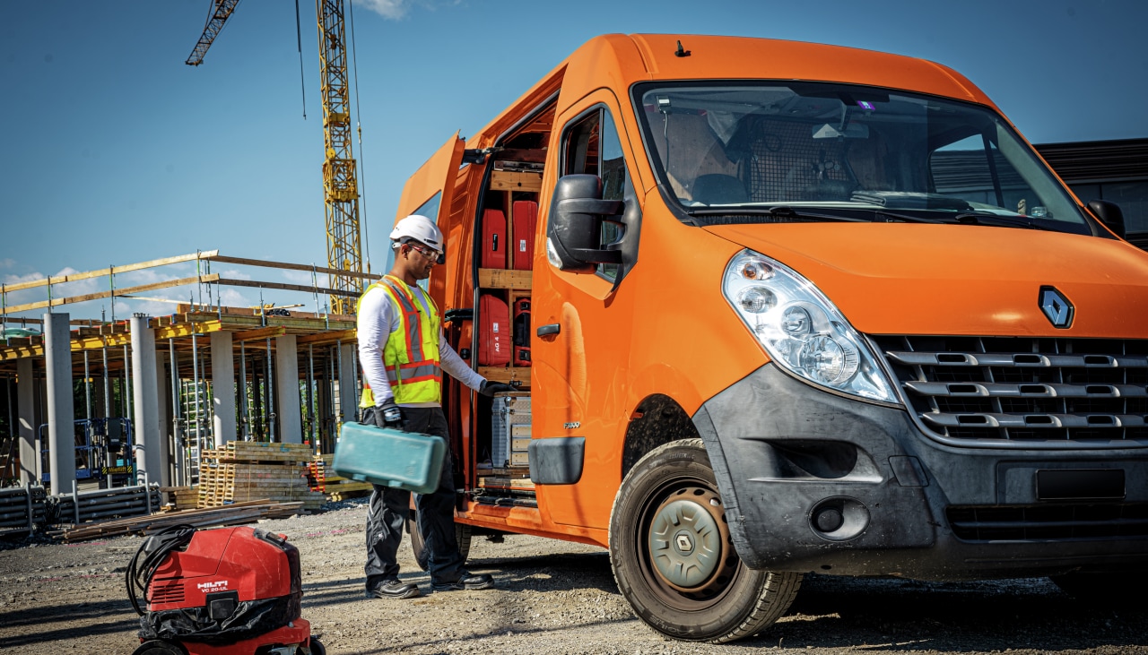 Een werfarbeider naast zijn vrachtwagen
